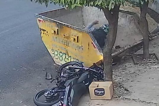 Após colidir com caçamba estacionada, motociclista fica inconsciente no interior da caixa metálica